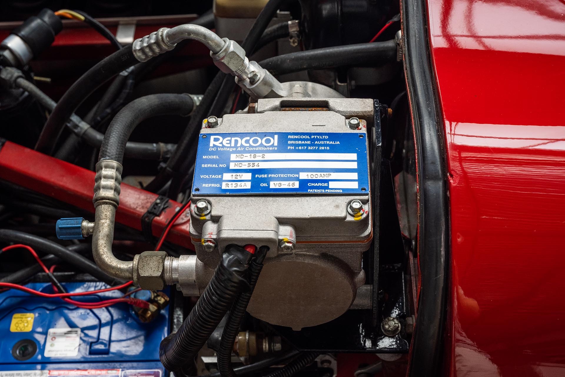 Rencool electric compressor installed in a red Jaguar engine bay.